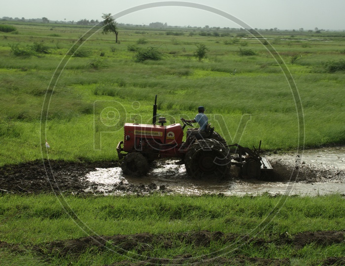 Indian Man  Ploughing With a Tractor In indian Fields