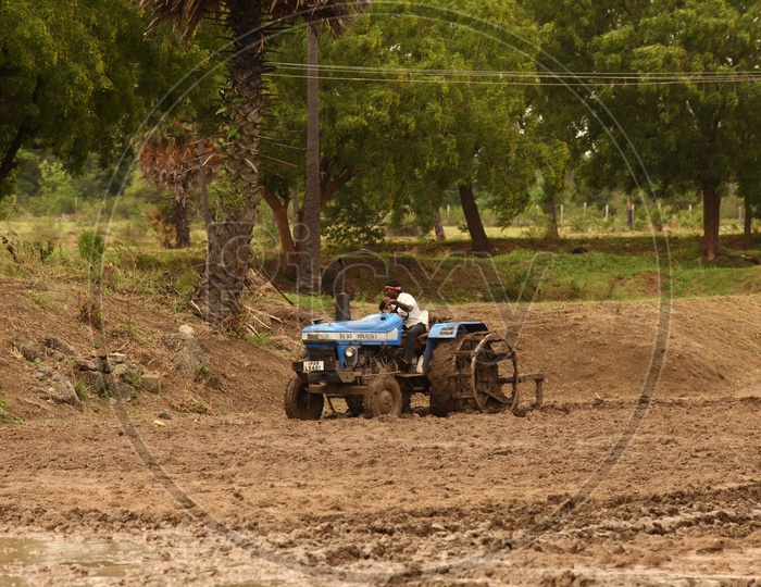 Indian Farmer With a Tractor in an agricultural Field