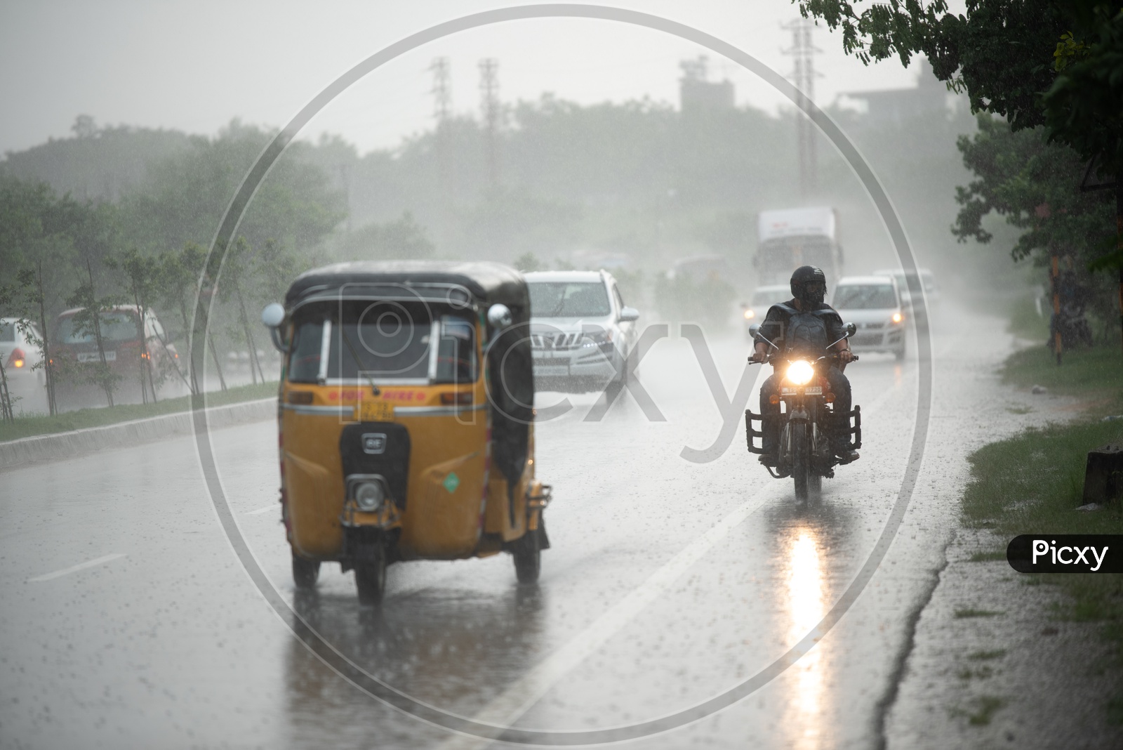 A Biker Travelling In Heavy Rain  on National Highway