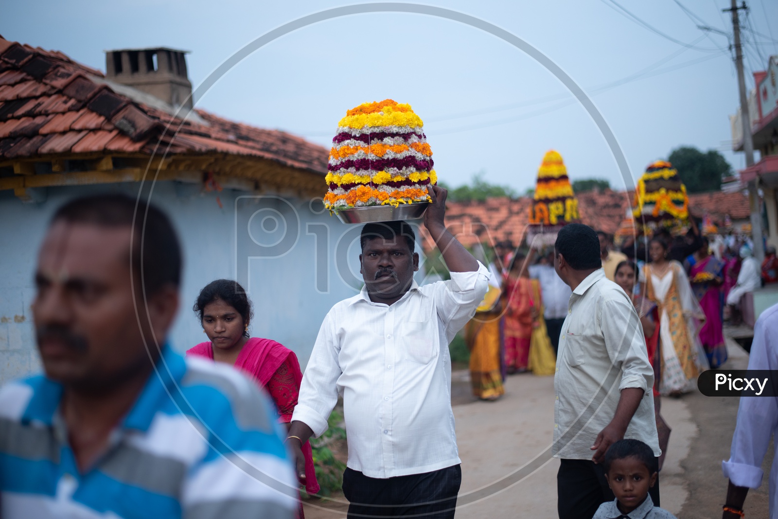 Men carry Bathukamma, a floral decoration  on Saddula bathukamma (pedda bathukamma) day in Telangana.