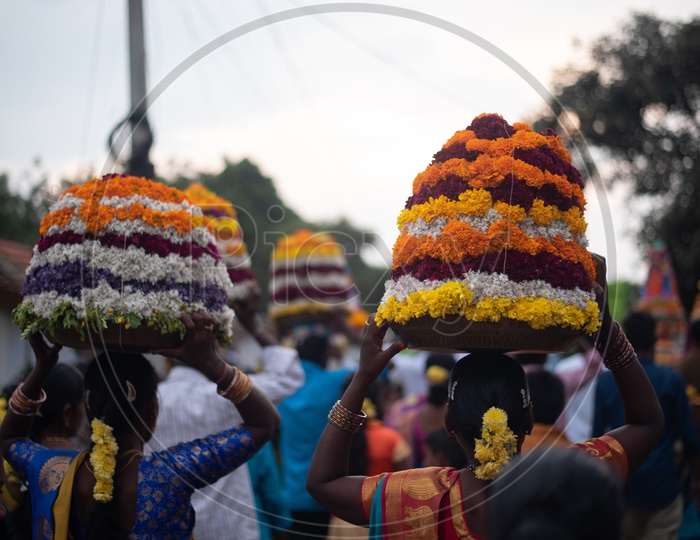 women carry Bathukamma, a floral decoration  on Saddula bathukamma (pedda bathukamma) day in Telangana.