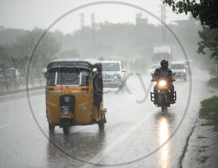 A Biker Travelling In Heavy Rain  on National Highway