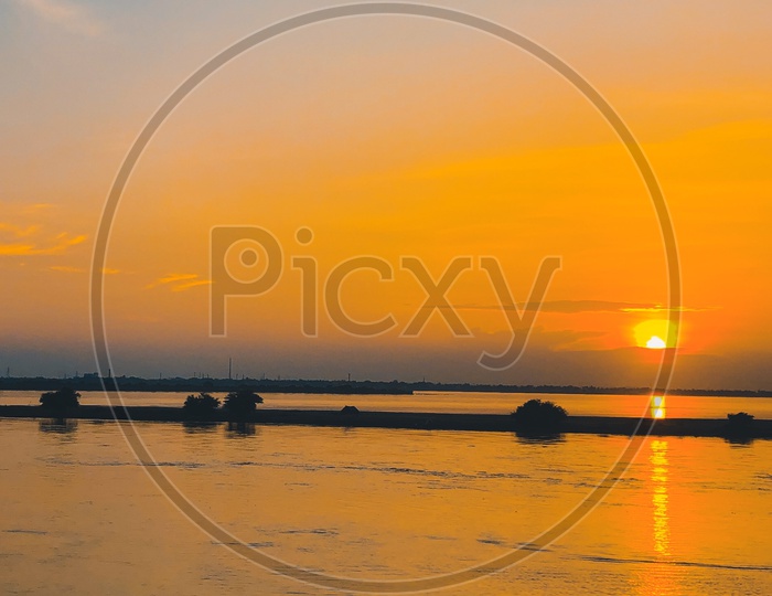 Silhouette of a fisherman with his boat during sunset along River Godavari