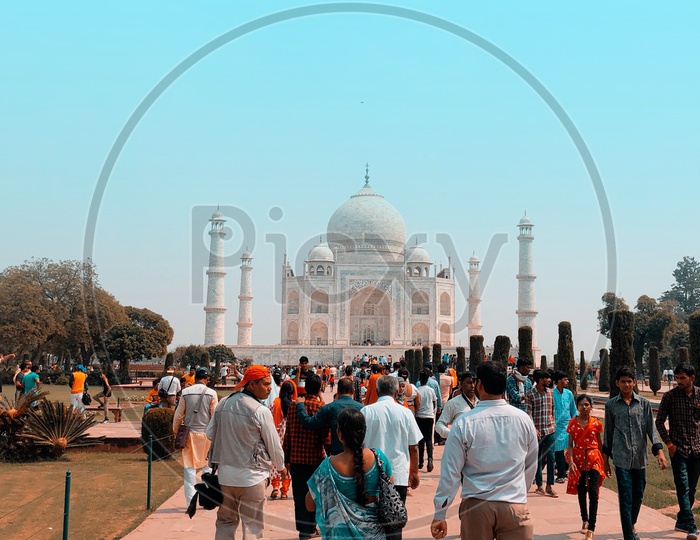 Tourists walking along the gardens of Taj Mahal
