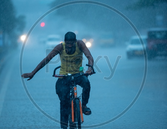 A Bicycle Rider Commuting In Heavy Rain