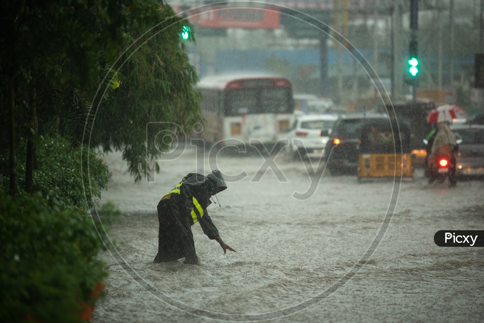 A GHMC Employee Working in Heavy Rain By Wearing Rain Coat