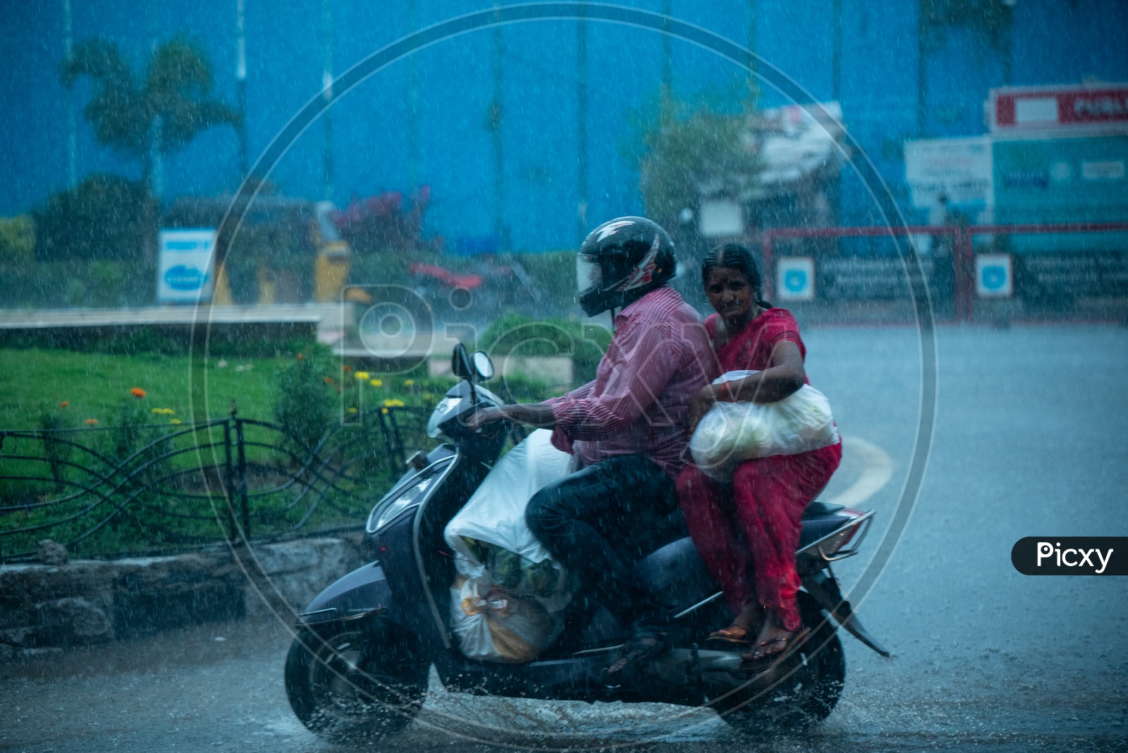 Husband And Wife Commuting In Heavy Rain On a Scooter