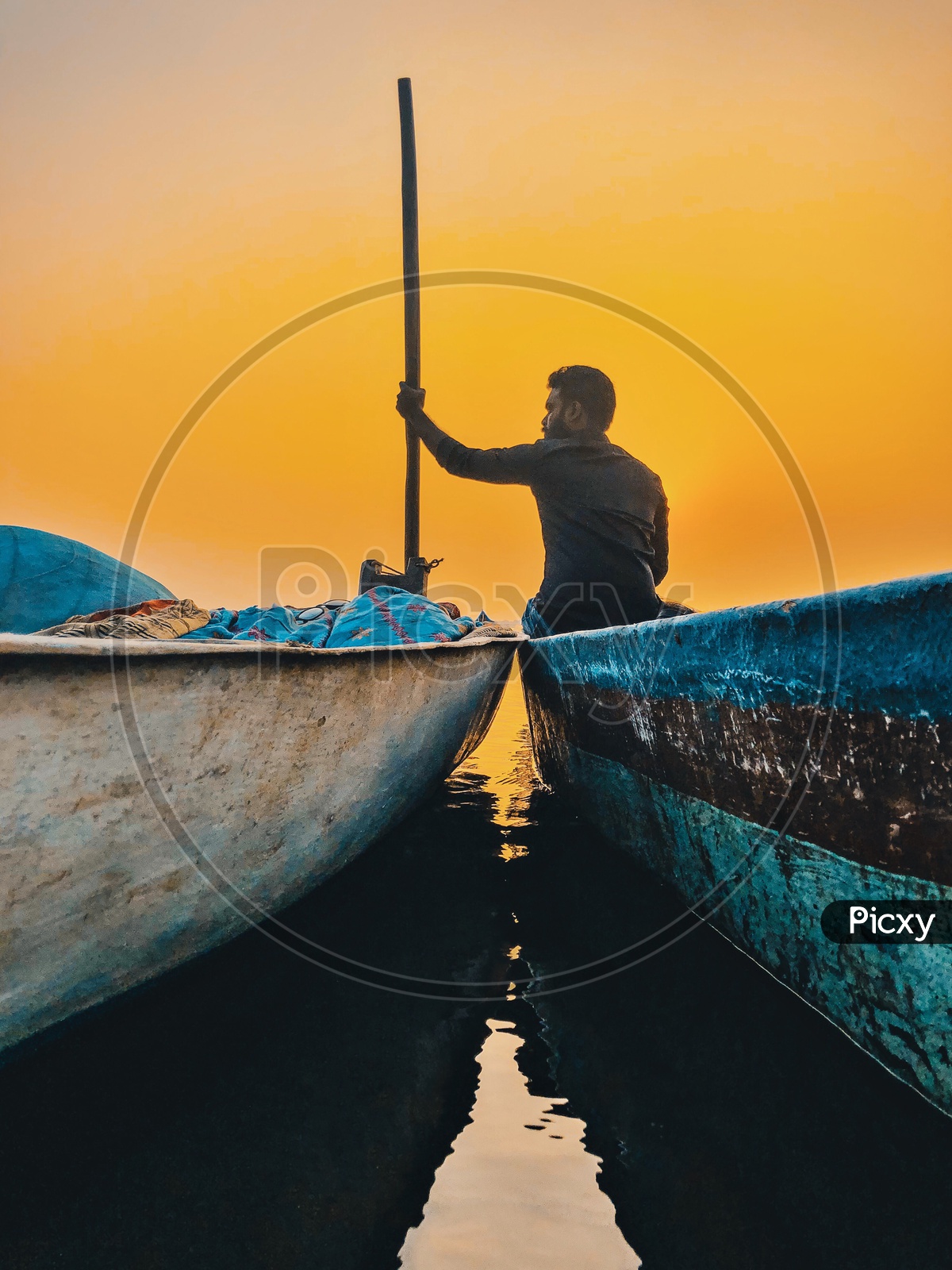 Indian Man enjoying the sunset by the fishermen boats