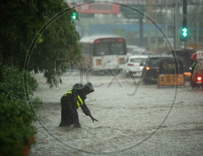 A GHMC Employee Working in Heavy Rain By Wearing Rain Coat