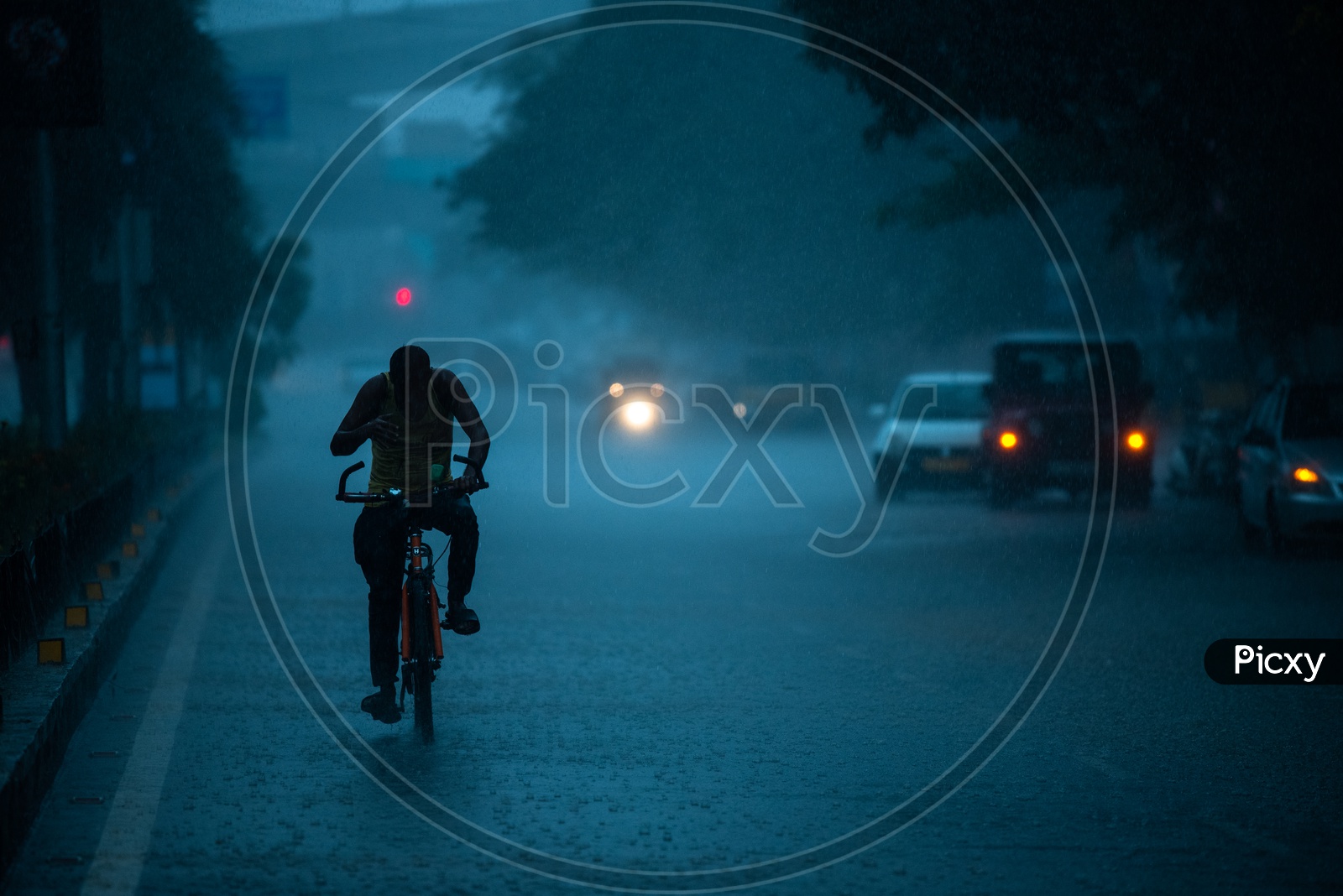 A Bicycle Rider Commuting In Heavy Rain near Shilparamam hitech city
