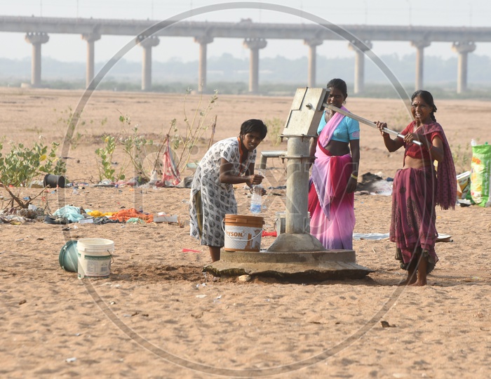 Indian Rural People pumping water from borewell