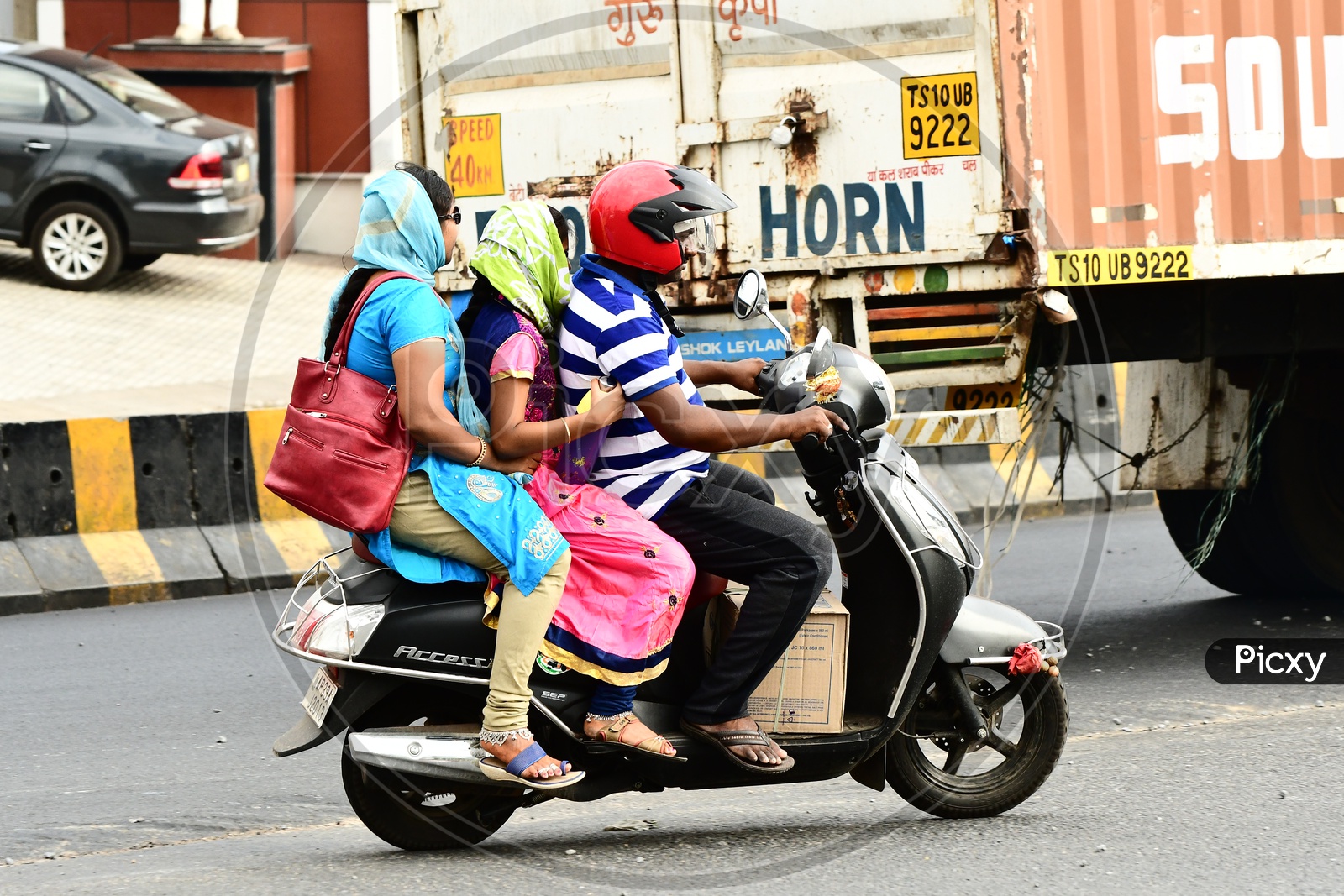 Indian Family riding triplets on the road