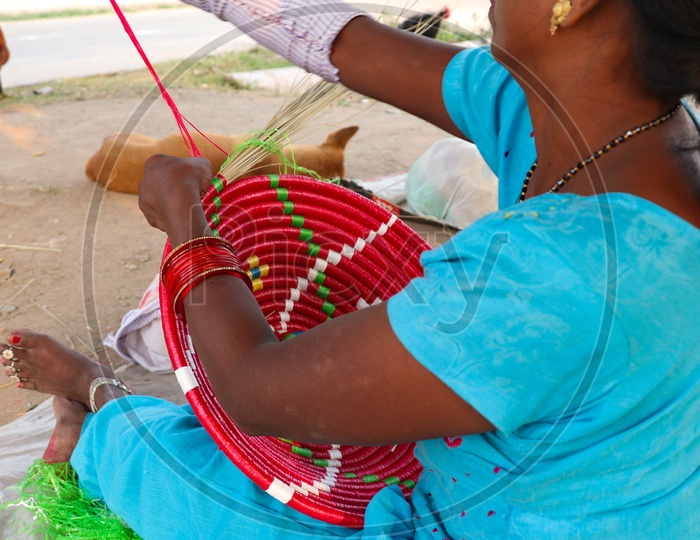 Indian Woman Preparing  Handmade Or Hand Weaved Baskets in a Road Side Vendor Stall