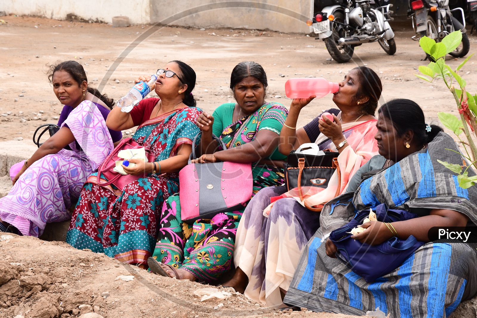 Group of Indian women sitting alongside the road