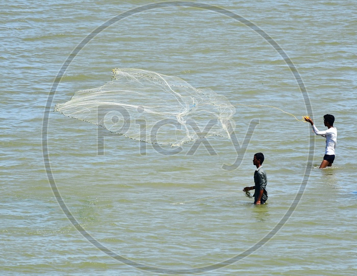 Fisherman Throwing Fishing Net In Krishna River  At Prakasham Barrage  In Vijayawada
