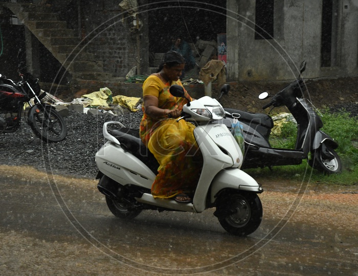 A Woman Bike Commuter Riding in Rain on Urban City Roads
