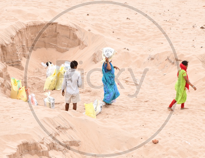 Indian workers carrying Sand in packets