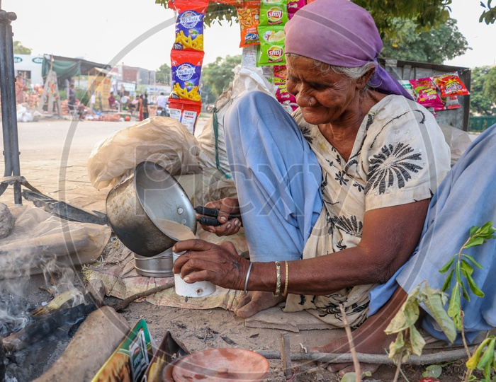 Indian Old Woman Making Tea On a Road side Pavement