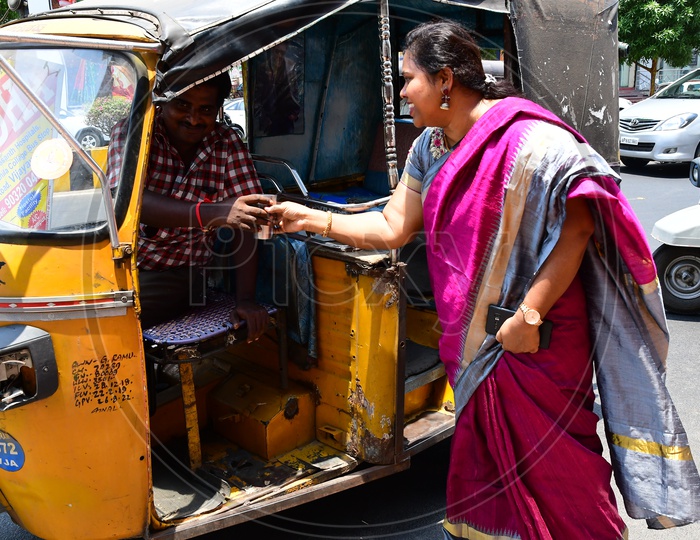 Indian Woman distributing Buttermilk to the Auto Driver during summer
