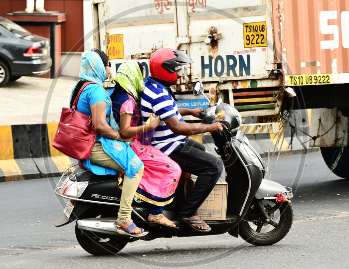Indian Family riding triplets on the road
