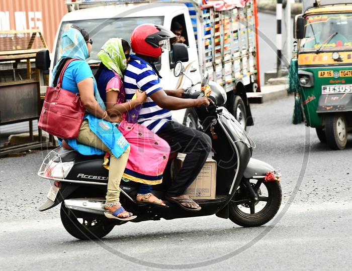 Indian family breaking the Traffic rules by riding triplets