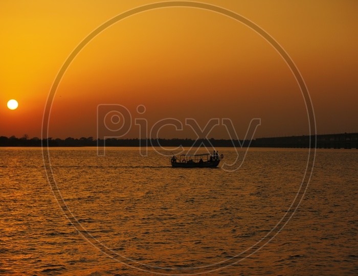 Silhouette Of a Fishing Boat on Godavari River With Sunset Sky Backdrop