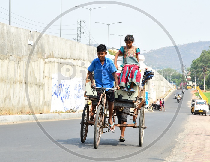 Young Indian Boy  Carrying Heavy Load On Rickshaw on Roads