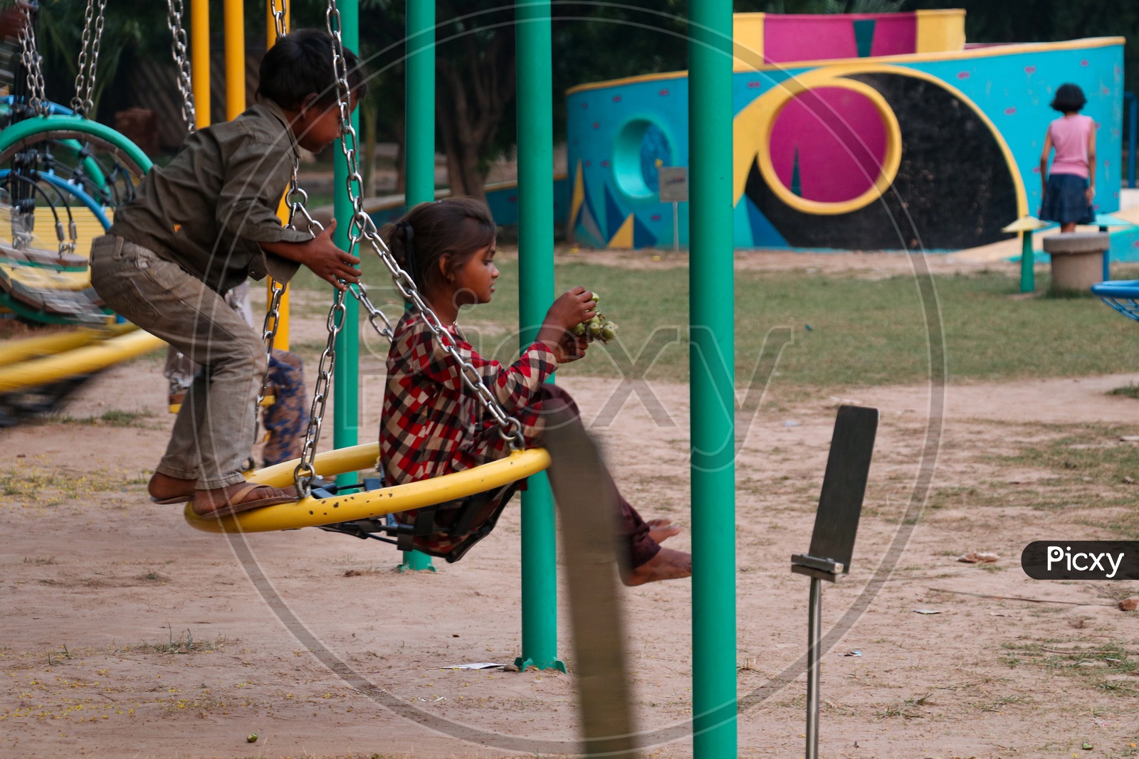 Indian Children playing With Swing In a Public Park