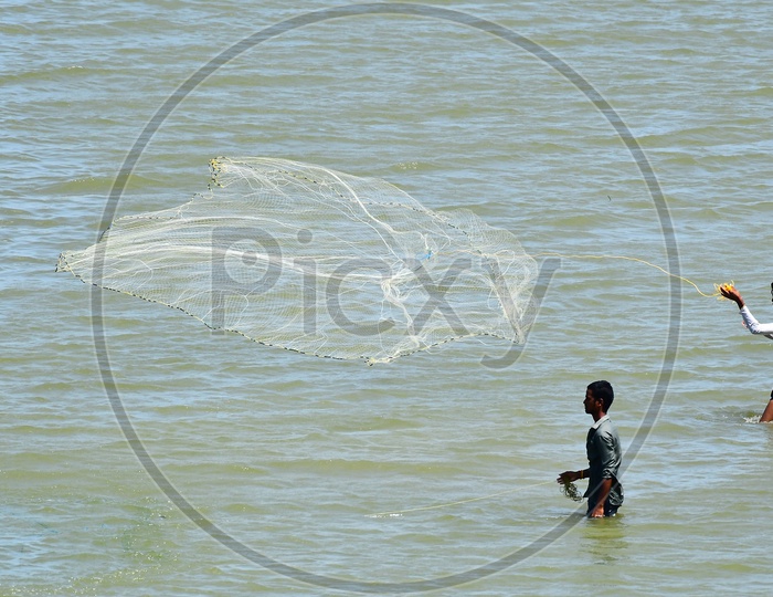 Image of Fisherman Throwing Fishing Net In Krishna River At Prakasham  Barrage In Vijayawada-JM038906-Picxy