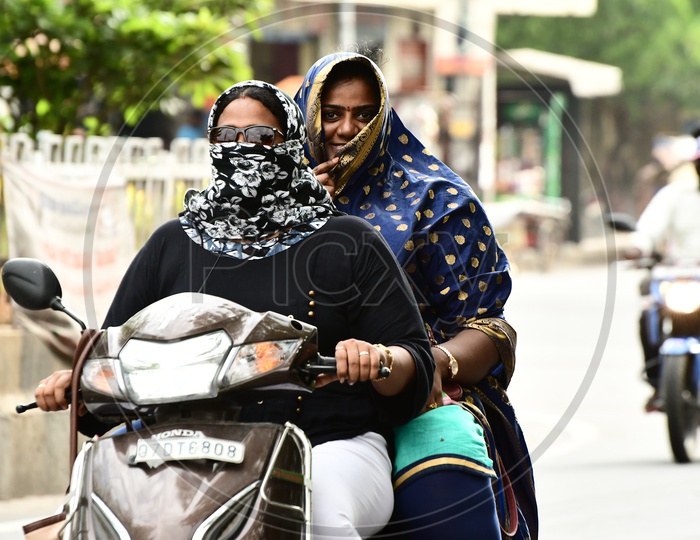 Indian Women riding Scooty wearing scarfs