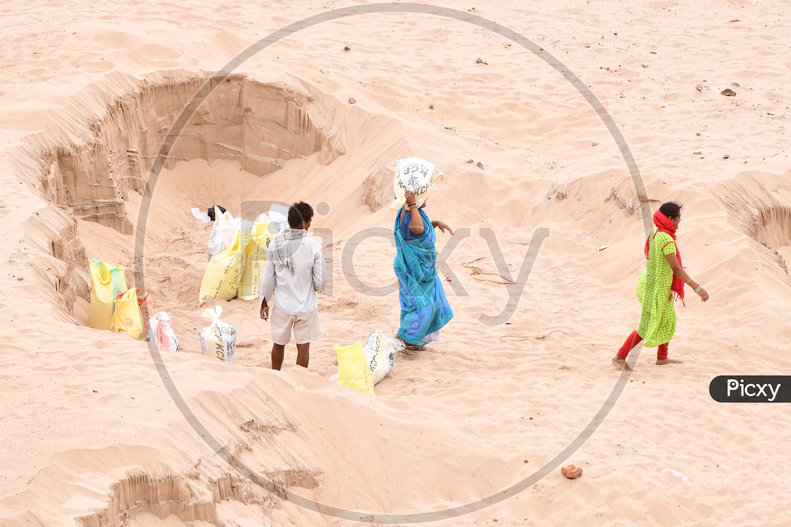 Indian workers carrying Sand in packets