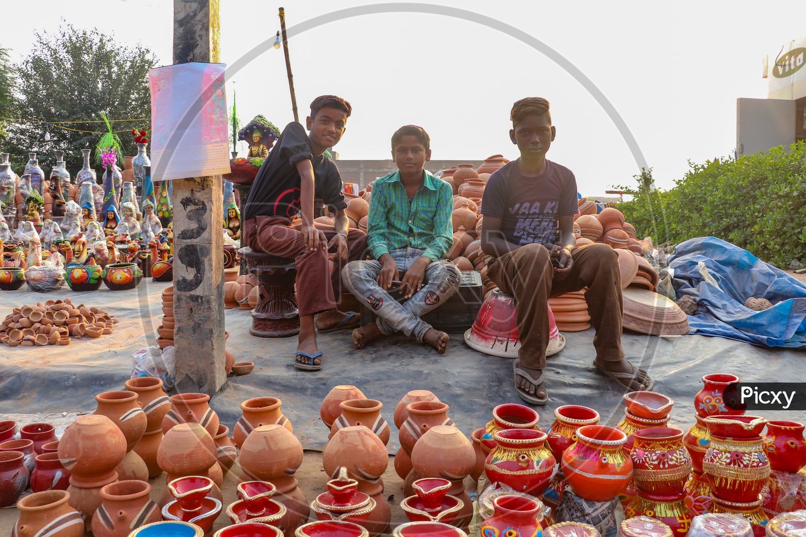 Indian Young Boys Selling Earthen Pots  At a Road Side Vendor Stall