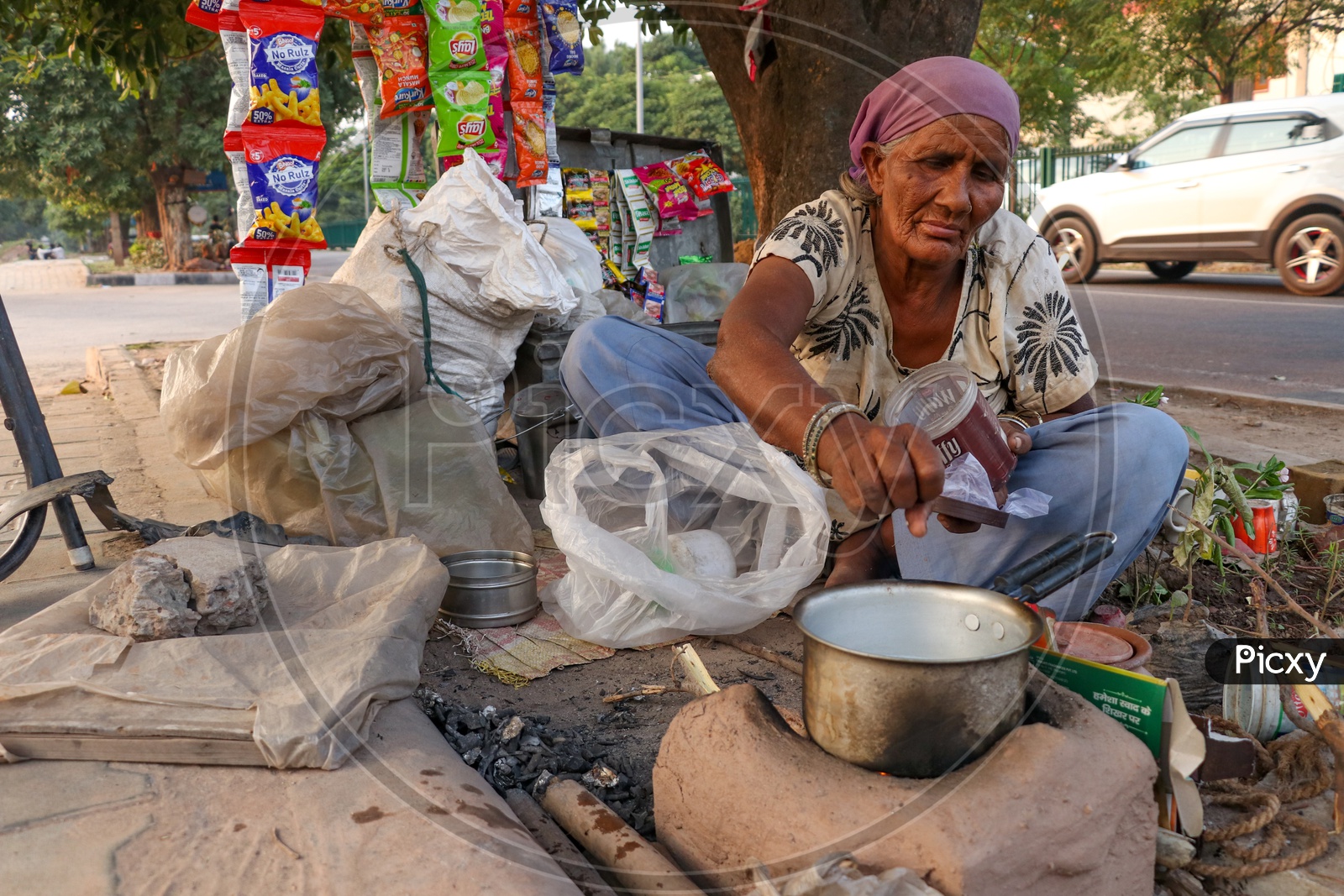 Indian Old Woman Making Tea On a Road side Pavement