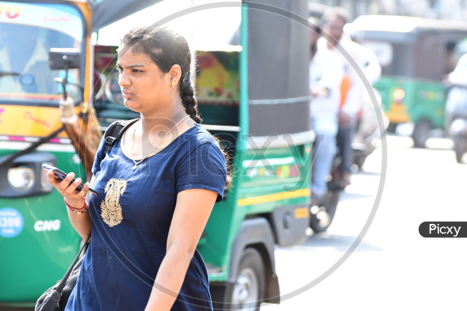 Indian girl walking holding a cellphone
