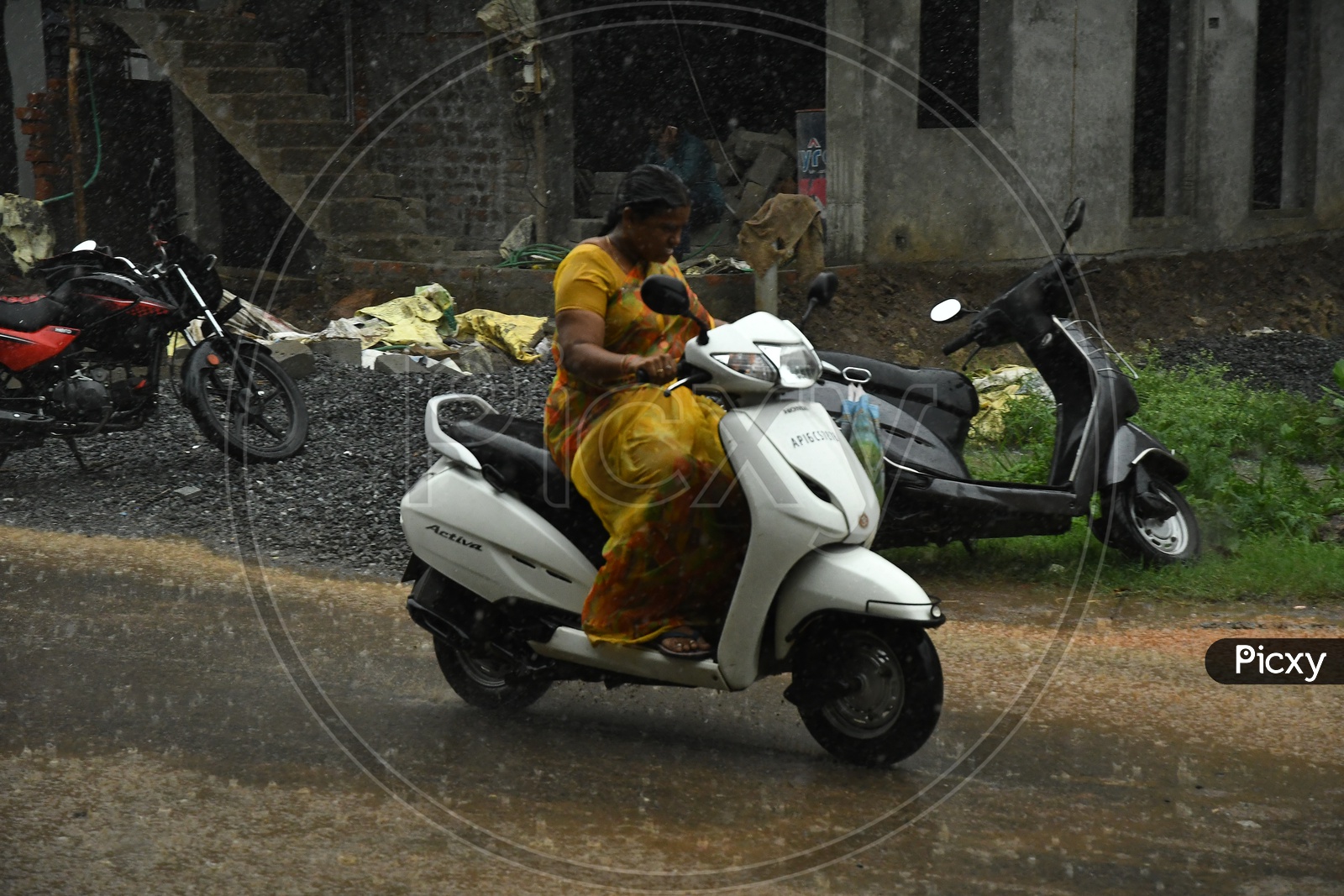 A Woman Bike Commuter Riding in Rain on Urban City Roads