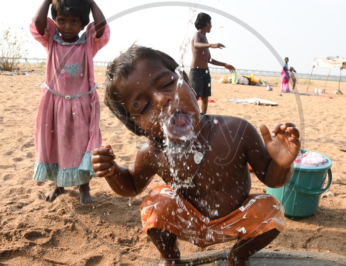 Indian Rural Kid drinking water from a bore well