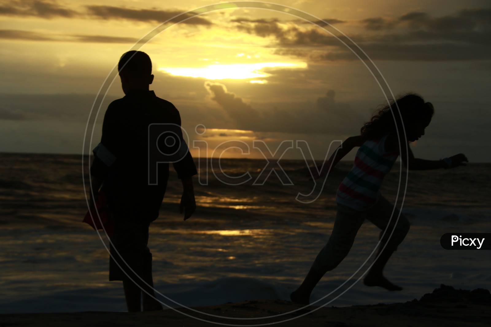 Silhouette Of Father And Daughter In a Beach With Sunset Sky In background