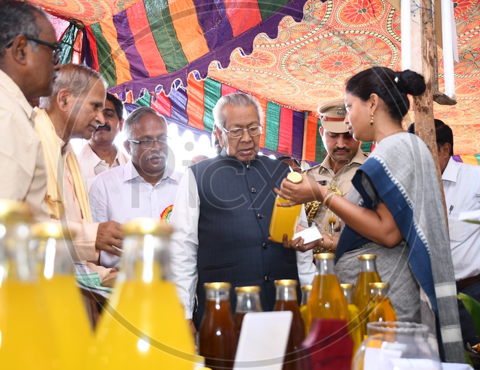 Volunteer showing the Organic health drink to Governor Biswabhusan Harichandan