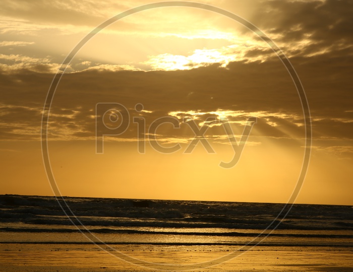 Beach With Golden Sunset Sky In Background