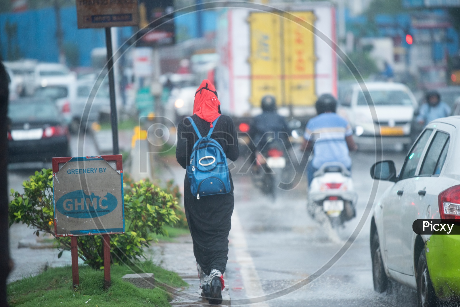 A Muslim Woman Walking on Footpath In Rain