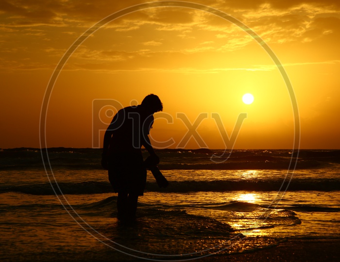 Silhouette of a Photographer Over a Sunset Sky At a Beach in Goa