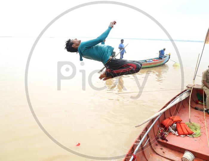 Indian Man diving into the river from a boat