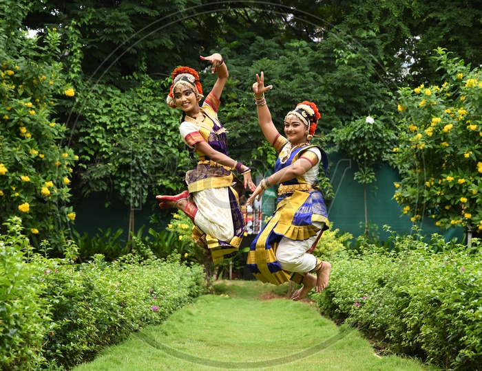 Indian Bharatanatyam Dancers jumping in the Lawn