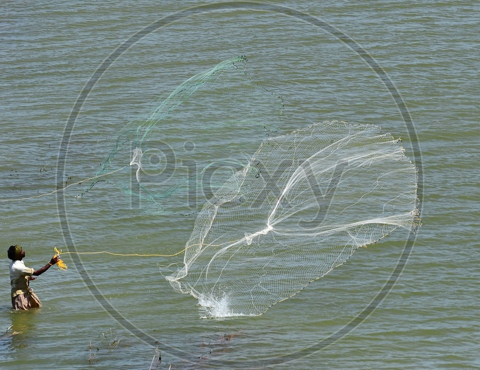 Fisherman Throwing Fishing Nets into River Water  For Fishing