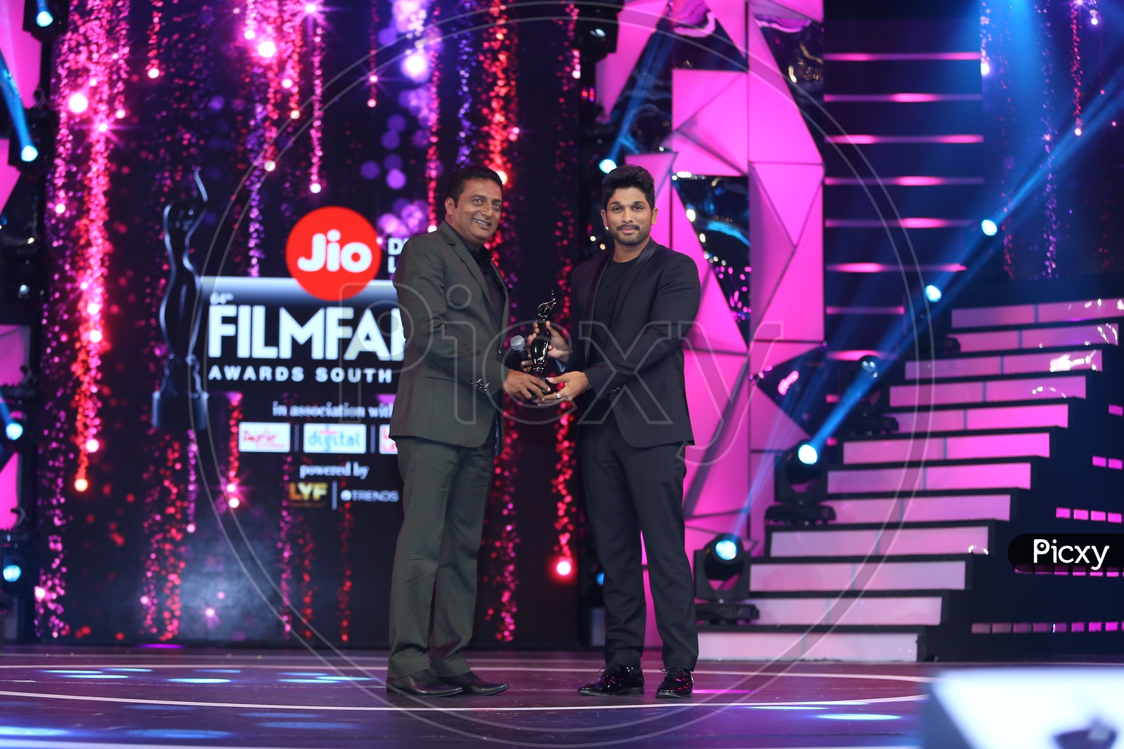 Actor Prakash Raj handing the filmfare award to Allu Arjun