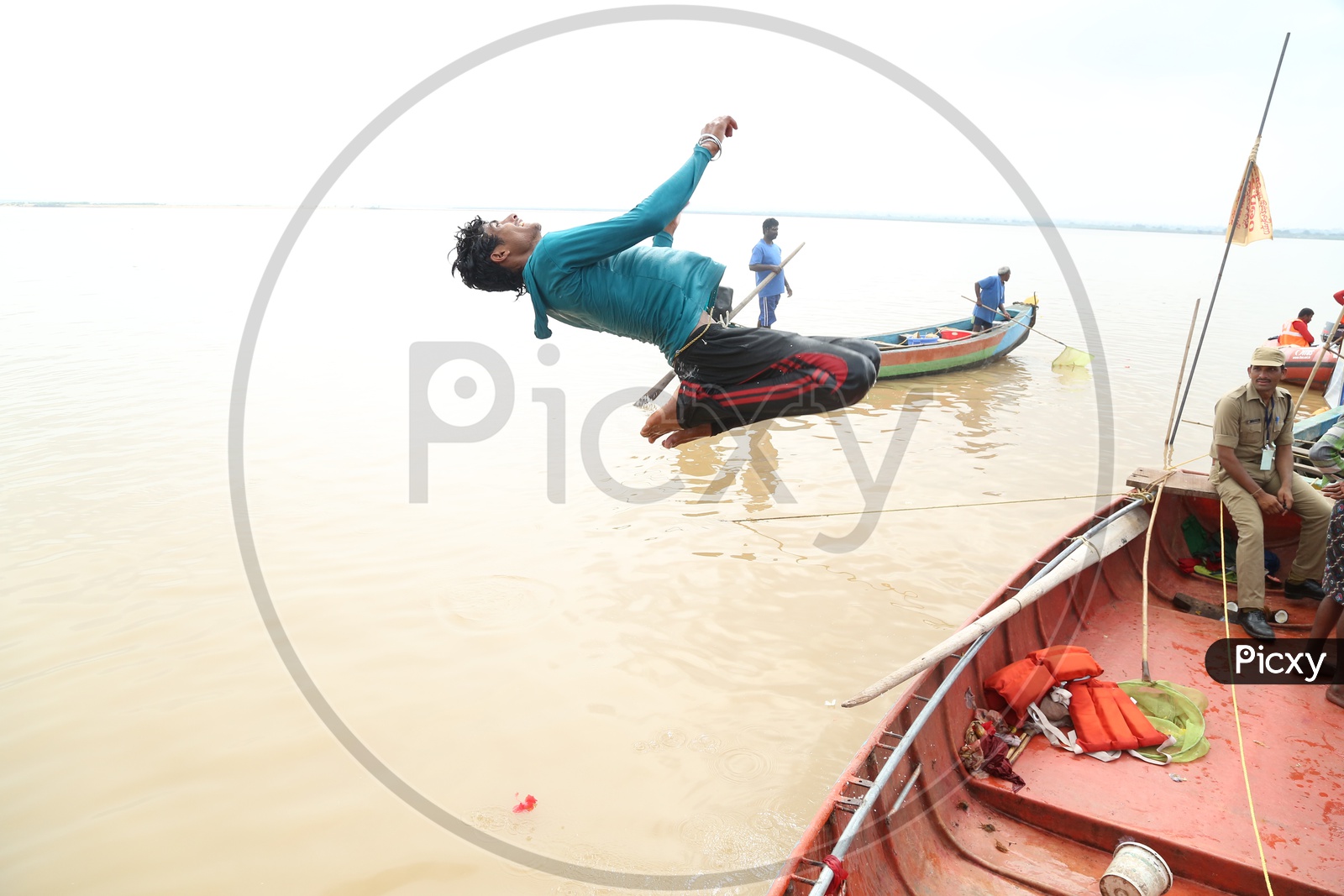 Indian Man diving into the river from a boat