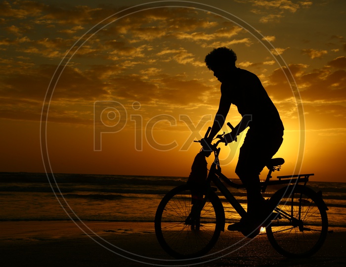Silhouette Of Bicycle Rider In a Beach