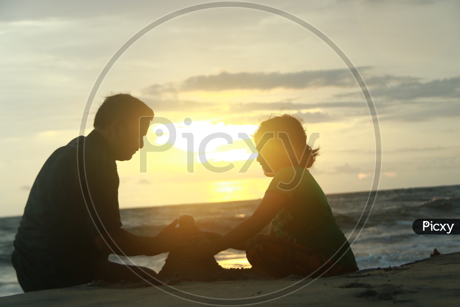 Silhouette Of a Father And Daughter Building Sand houses in a Beach