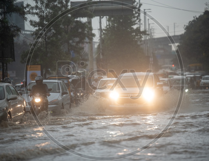 Commuters Struggles on Flooded Roads During Heavy Rain Near Hi Tech City