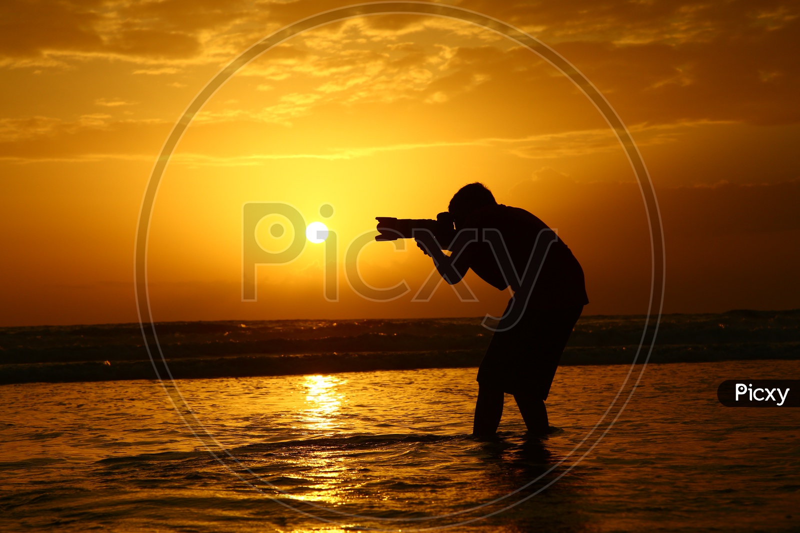 Silhouette of a Photographer Over a Sunset Sky At a Beach in Goa